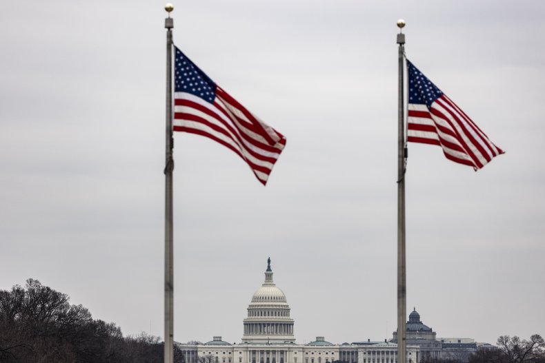U.S. Capitol behind waving American flags
