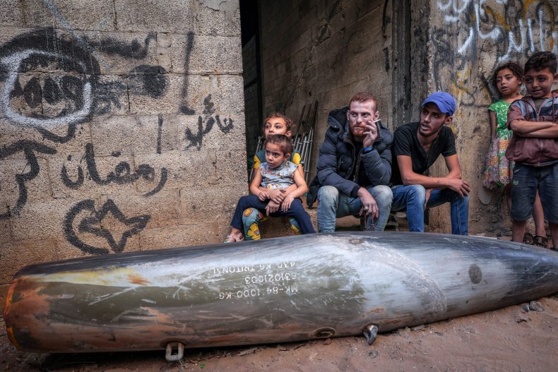 Palestinians sit by Israeli bomb in Gaza