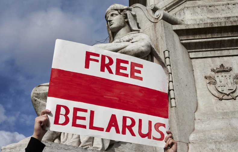 A demonstrator hoists a Free Belarus poster