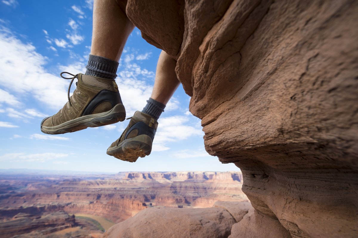 Hiker Resting with Boots Dancing Above Canyon