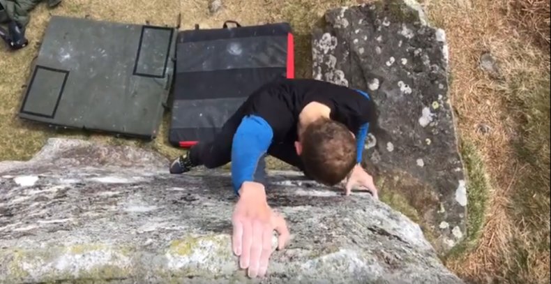 Sam Pilcher climbs a sheer rock face.