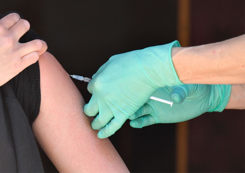 Health care worker injects COVID vaccine dose.
