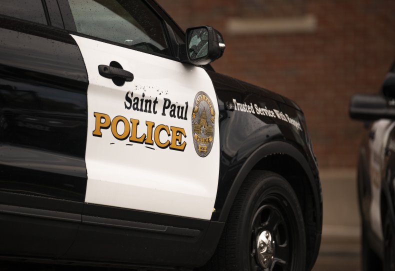 Police cars stand parked outside a courthouse.