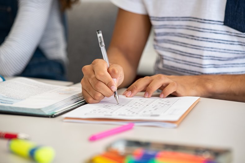 Student writing on paper