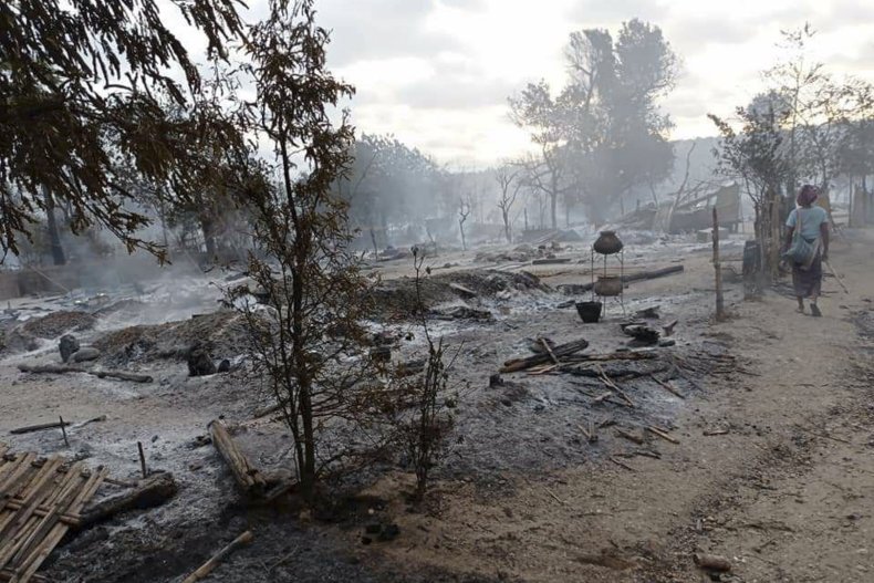 A Resident Walks Past Burning Houses