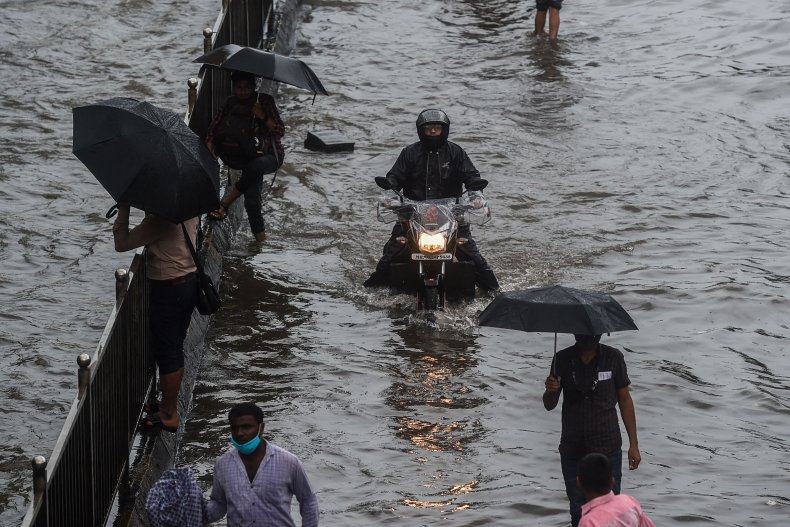 Commuters make their way through flooded roads