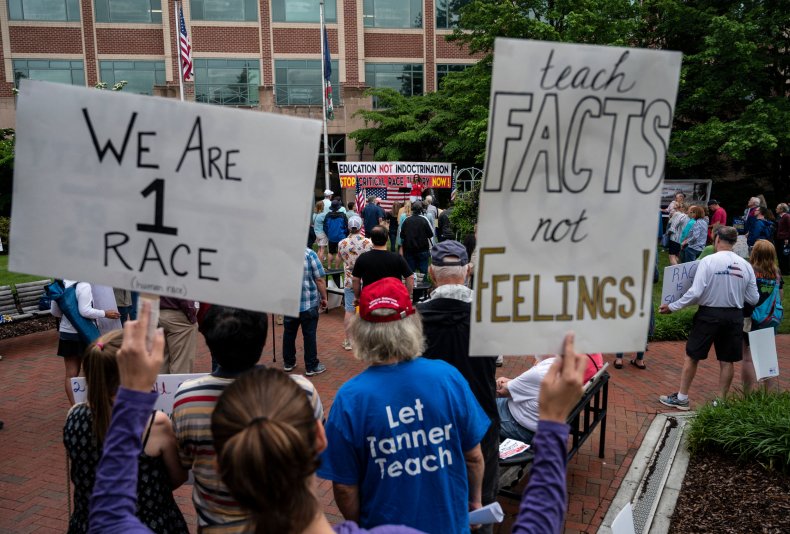 People hold up signs during a rally