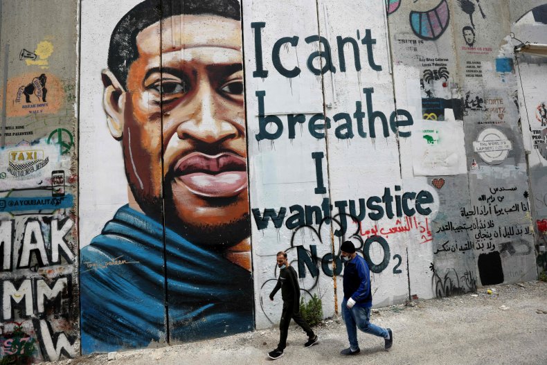 People Walk Past a George Floyd Mural