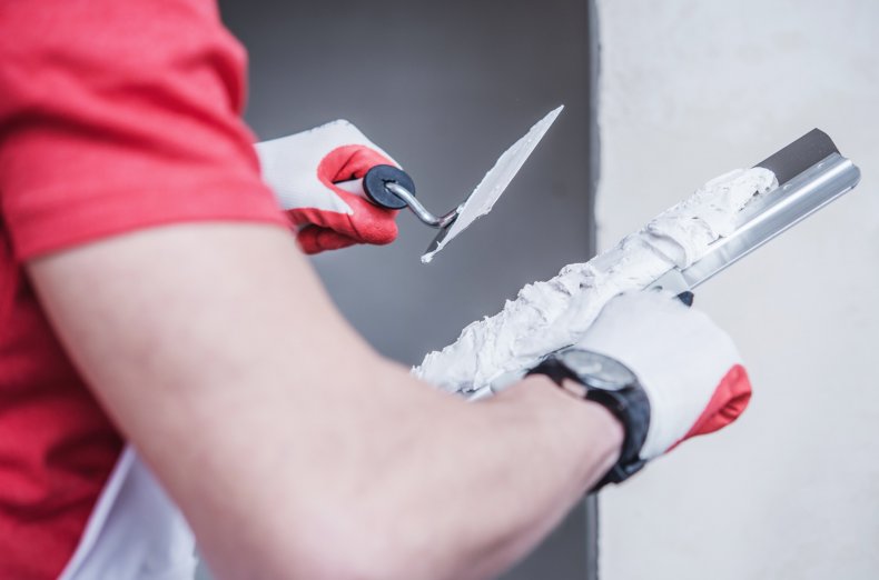 Construction worker applying drywall compound