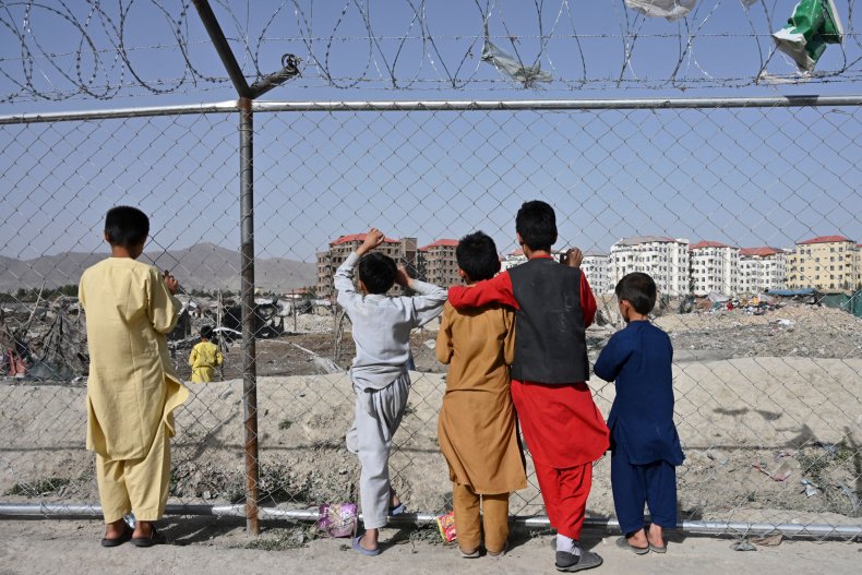 Children watch people at a camp