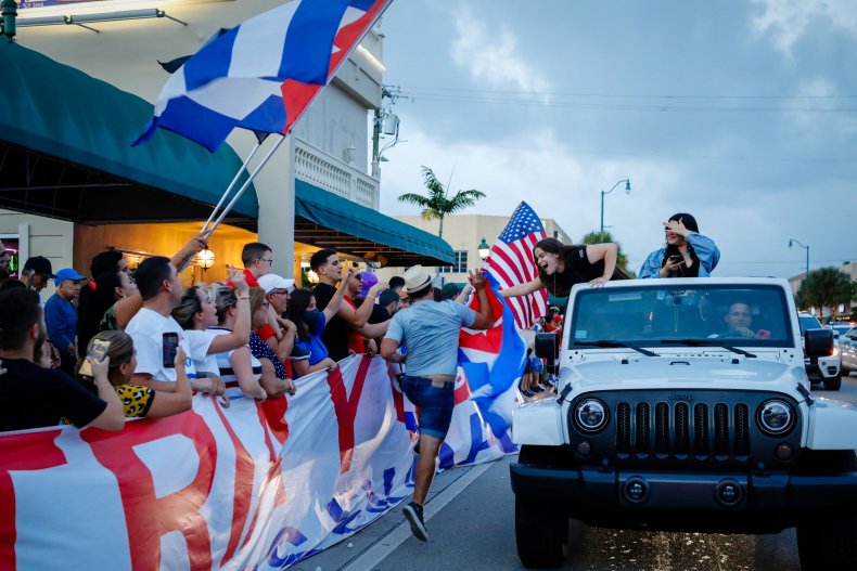 People wave US and Cuban flags during