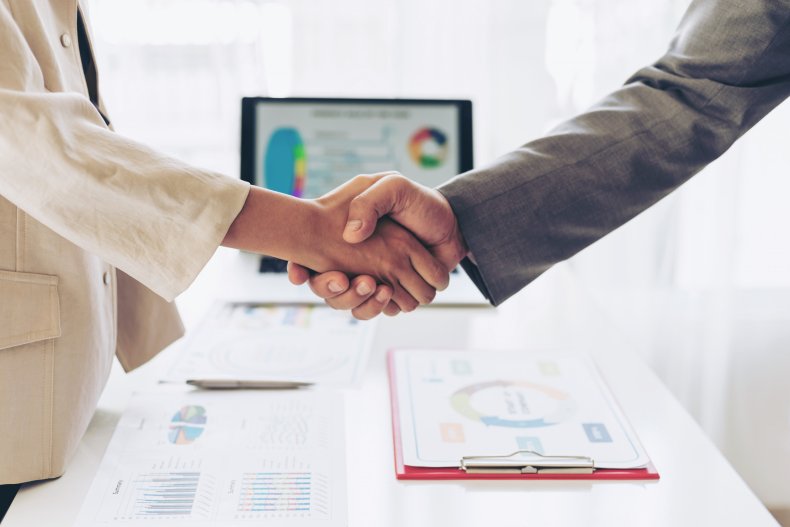 People shaking hands at a meeting.