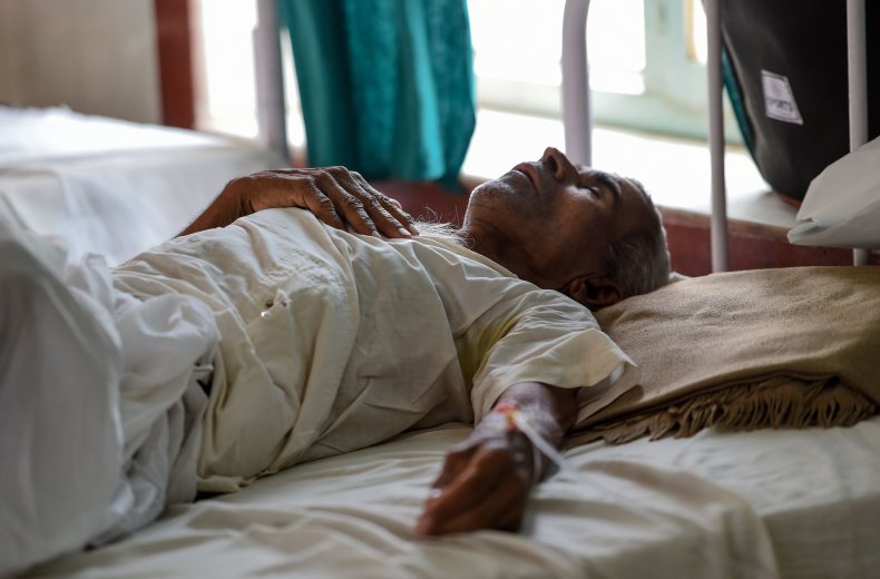 A man lies in a hospital bed.
