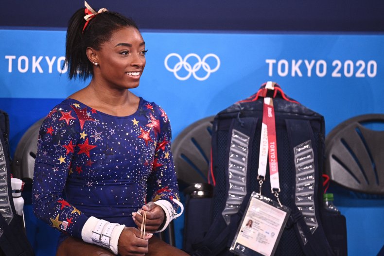 Simone Biles smiles on the sidelines.