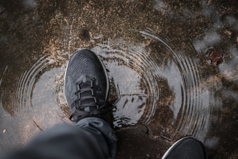 Man walking through puddle
