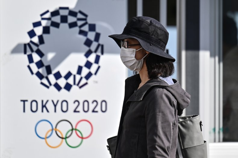 A woman near a Tokyo 2020 poster.