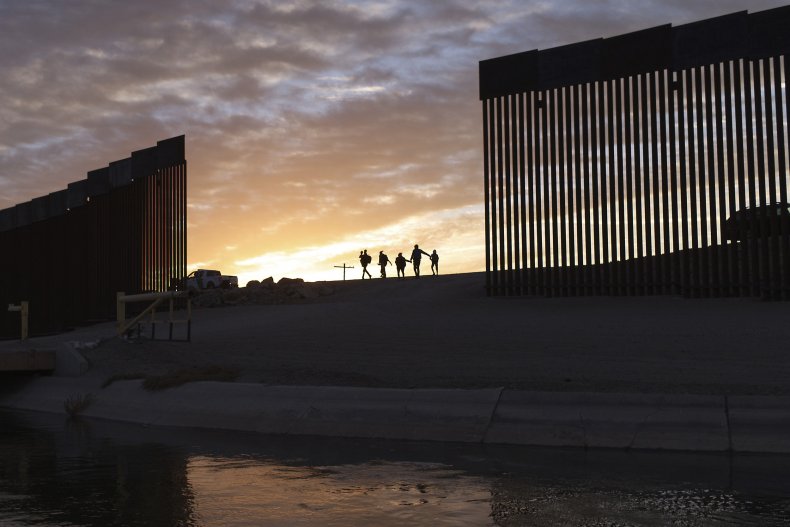 Migrant Families Pass Through Border Wall