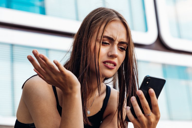 A woman reacting to her phone.
