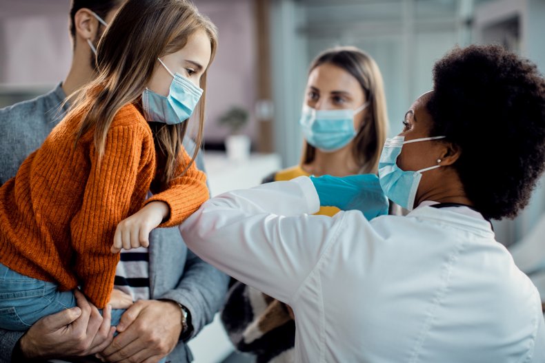 Paediatrician elbow bumping with child