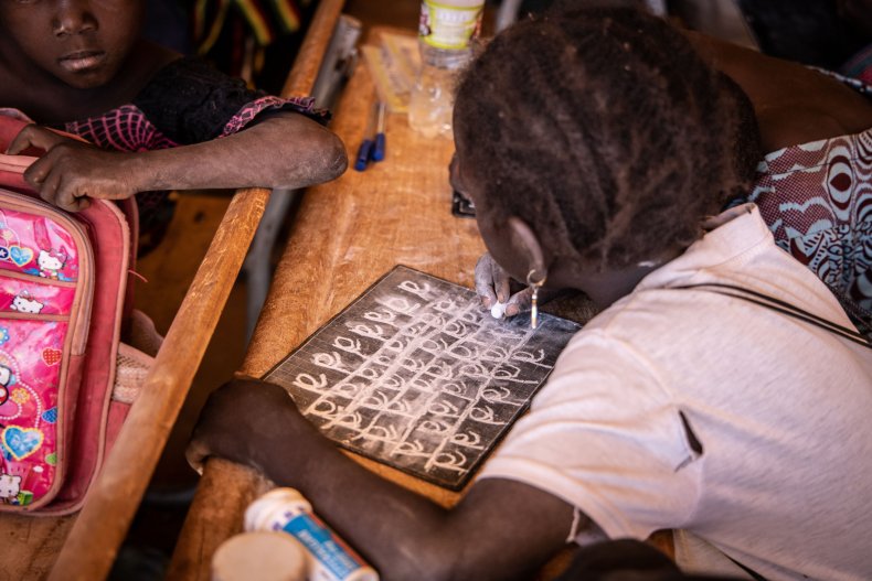 A primary schoolgirl writes on her board