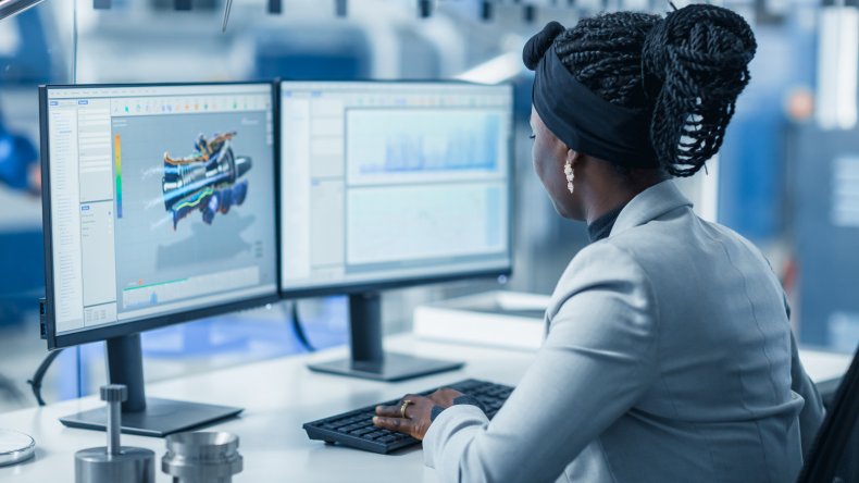 Woman working at desk with two screens