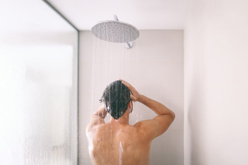 Man washes his hair in the shower