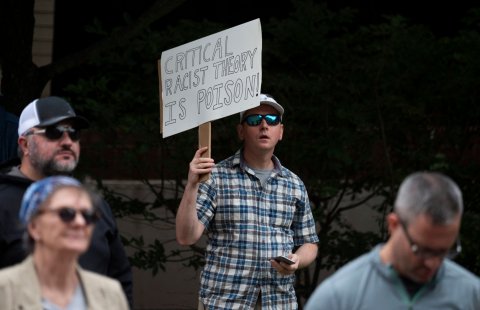 critical race theory protester holding sign