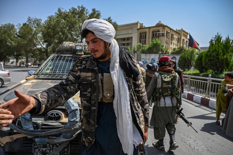 Taliban fighters stand guard along a street