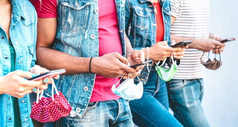 Friends look at their cell phones