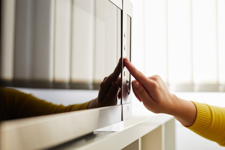 Woman pressing buttons on a microwave