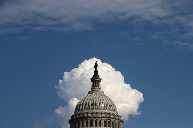 A cloud rises behind the U.S. Capitol