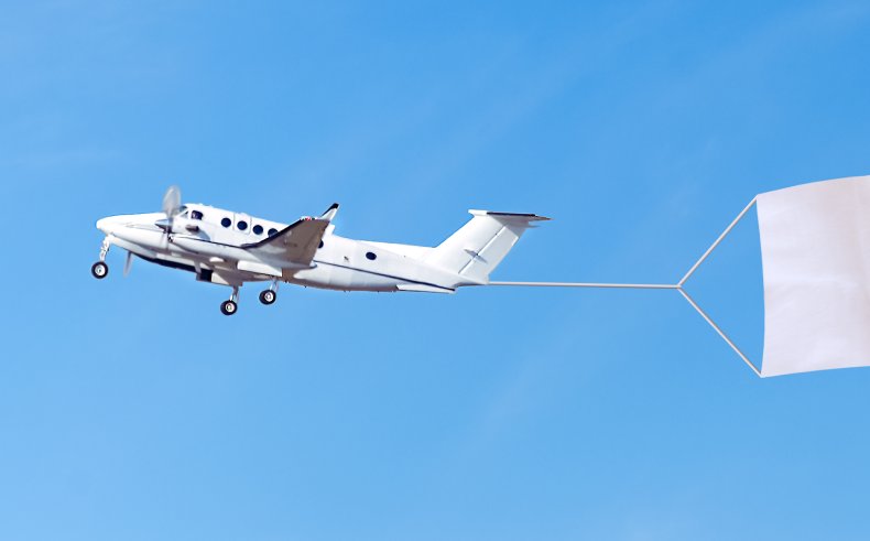A plane flying with a banner behind.