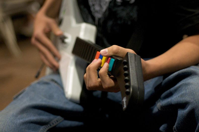 A man playing Guitar Hero.