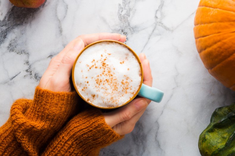 Woman holds pumpkin spice latte