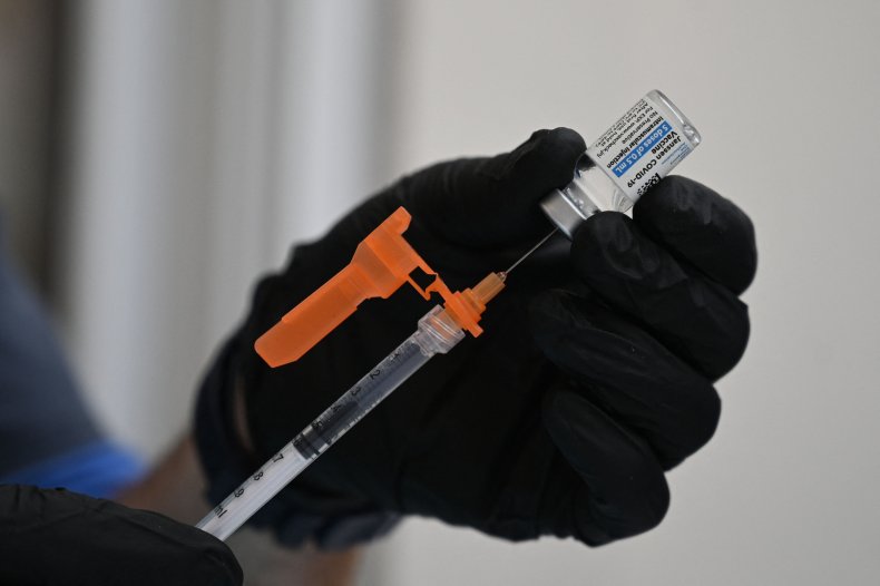nurse fill syringe with covid vaccine