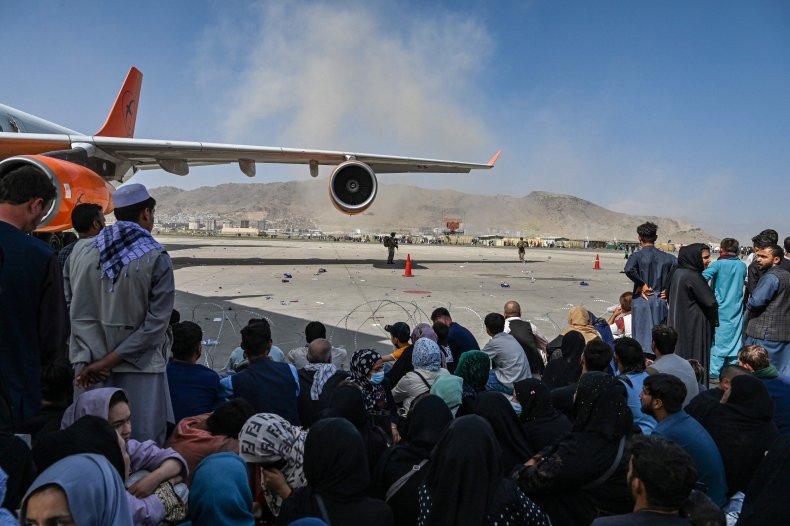 Afghan people wait to leave Kabul airport