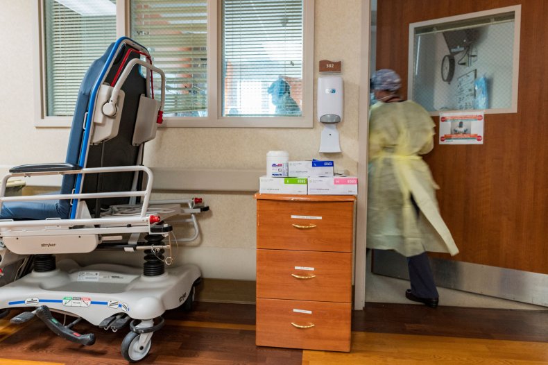 A nurse enters a COVID-19 patient's room