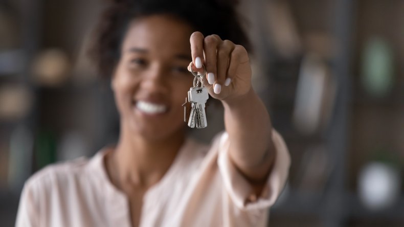 A woman holding up some keys.