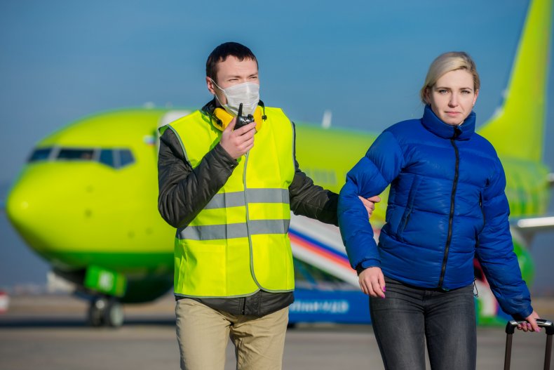 A woman being escorted from a plane.
