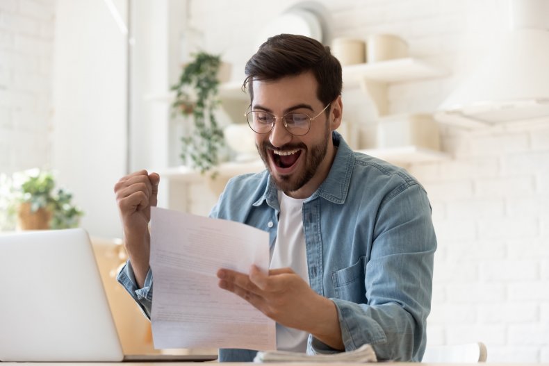 A man reacting delightedly to a letter.