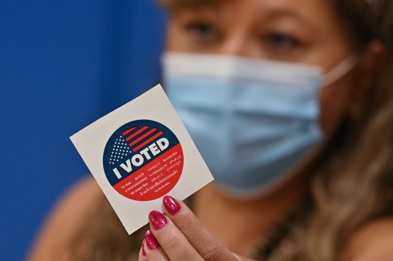 A poll worker with a voting sticker.