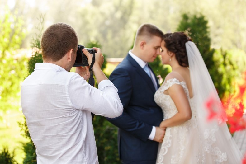 A wedding photographer, bride and groom.