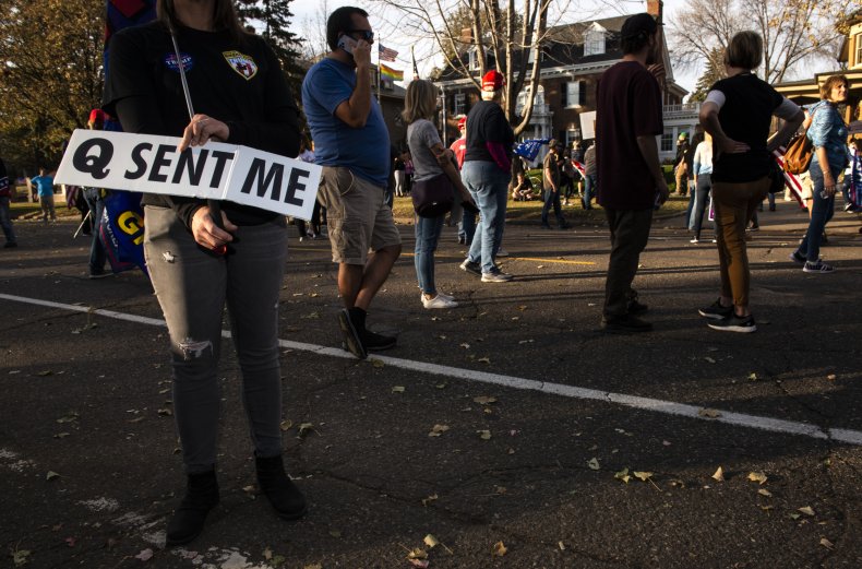 A woman holding a QAnon sign.