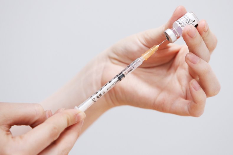 A staff member prepares a Pfizer vaccine