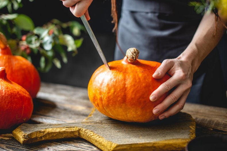 Person cutting a pumpkin