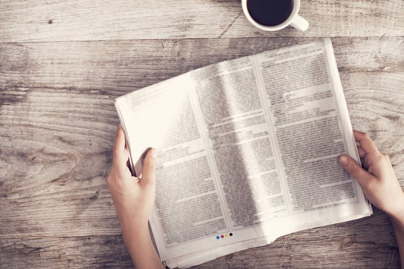 A person reading a newspaper.