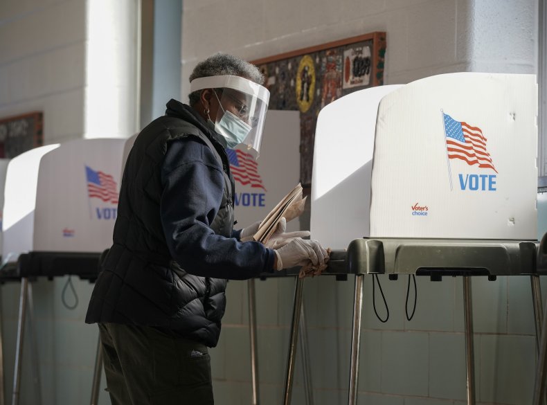 A poll worker cleans a voting booth