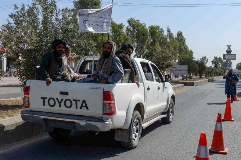 Taliban fighters sitting on a vehicle