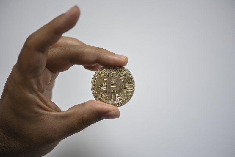 Un homme montre un bitcoin souvenir 