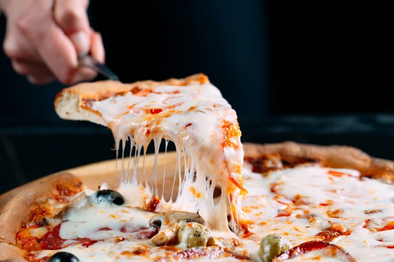 Man cuts a slice of pizza
